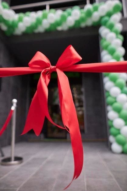 Openingsceremonie met rood lint en groen-witte ballonboog